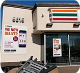 7-Eleven exterior We Now Deliver building banner